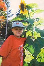 
My son James is standing on a three-foot stool next to his sunflower. He brought home the young seedling after planting it in class, and we watched it grow, and grow... and grow.—Sharlynn Buckley
